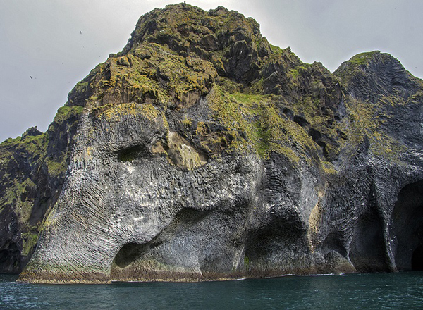 Natural rock formation looks like an elephant drinking from the ocean