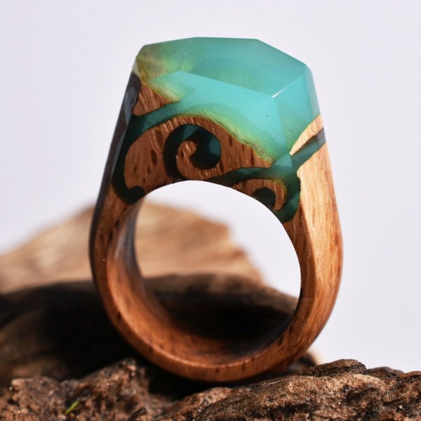 Enchanting miniature worlds inside wooden rings by Secret Wood