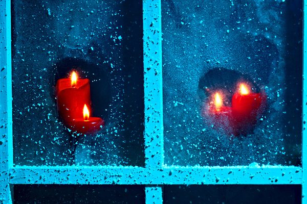 Christmas night! Frozen window burning candles